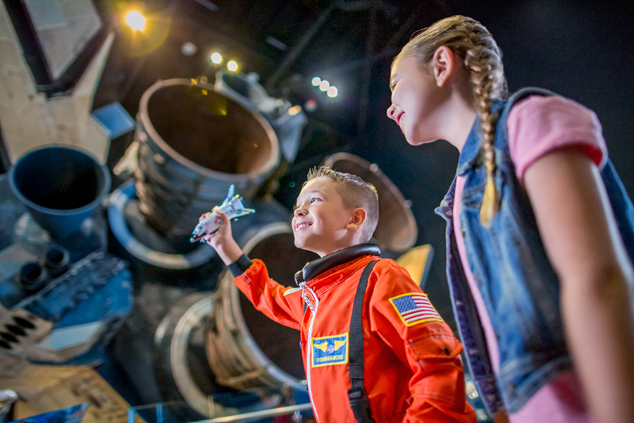 Two children explore the Space Shuttle Atlantis attraction at Kennedy Space Center Visitor Complex.