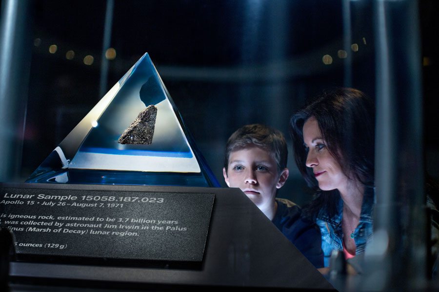 Mother and son gaze in awe at the Moon Rock on display at the Apollo/Saturn V Center