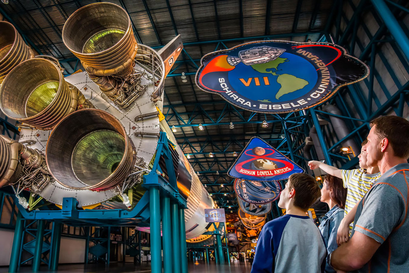Family looks up to the Saturn V moon rocket on display at the Apollo/Saturn V Center.