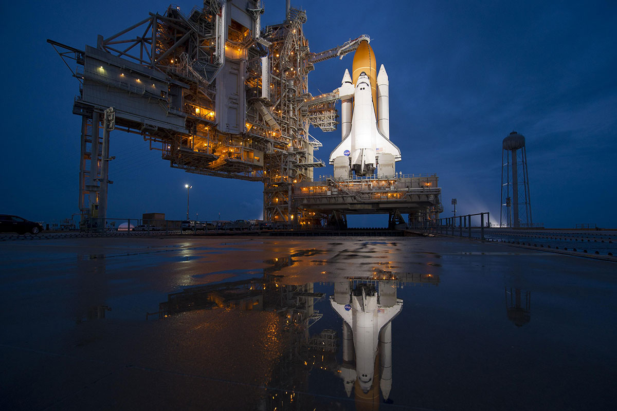 Space shuttle Atlantis sits on the Launch Pad at night in preparation for a flight.