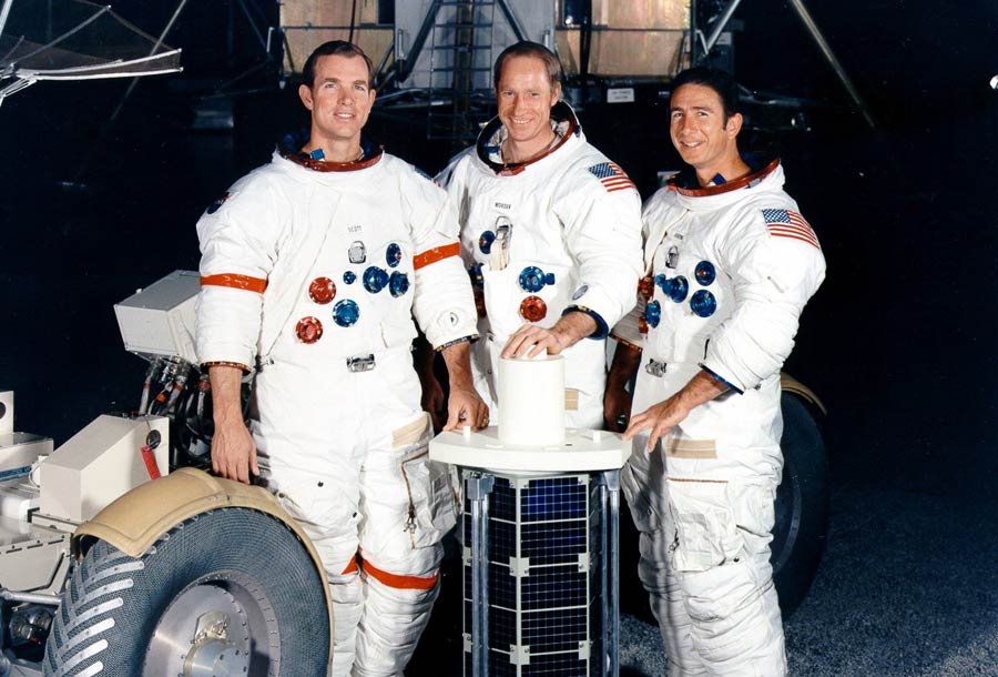 (Left to right) Scott, Worden, and Irwin pose with the subsatellite they will release in lunar orbit.