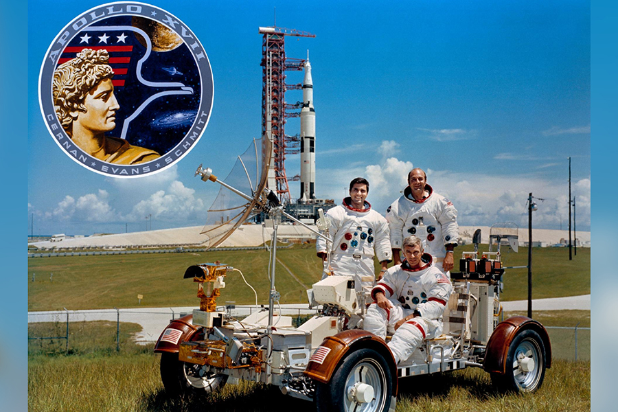 Apollo 17 astronauts in front of Saturn V rocket on LRV