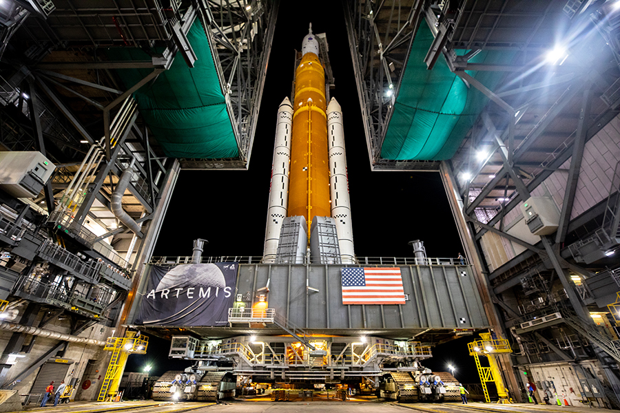 Space Launch System (SLS) on mobile launcher and crawler viewed from inside the Vehicle Assembly Building (VAB)
