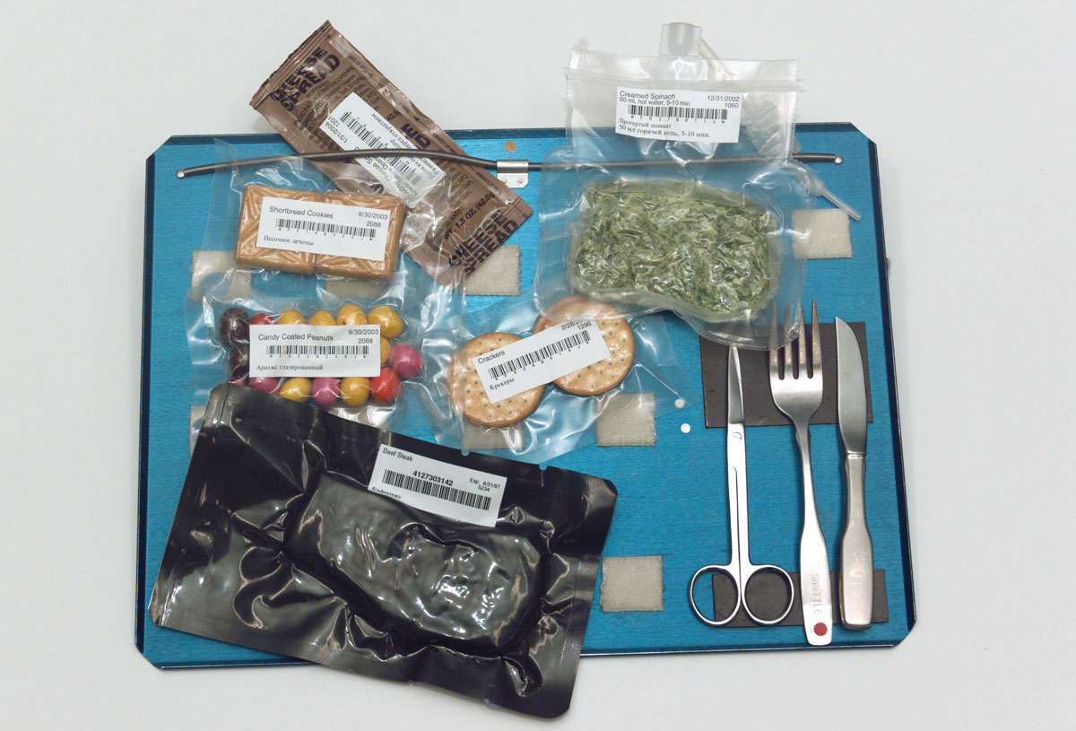 Utensils and bags of food on tray. Photograph taken at Johnson Space Center’s Food Tasting lab.