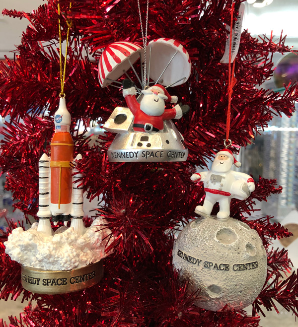 Three space related Christmas ornaments in a red christmas tree.
