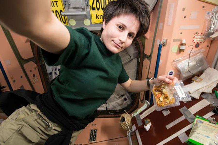 Expedition 42 Flight Engineer Samantha Cristoforetti of the European Space Agency (ESA) prepares her dinner.