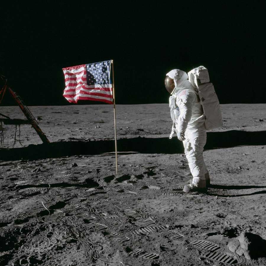 Astronaut Edwin E. Aldrin Jr., lunar module pilot of the first lunar landing mission, poses for a photograph beside the deployed United States flag during an Apollo 11 extravehicular activity (EVA) on the lunar surface.