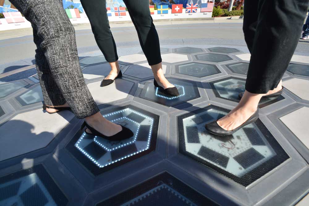Guests lighting up the Step. Tower. Launch! power tiles using piezoelectric energy.