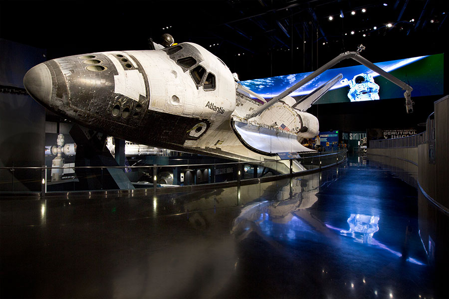 Atlantis is displayed as only astronauts have seen her in space, rotated 43.21 degrees with payload doors open and Canadarm extended, as if just undocked from the International Space Station (ISS).