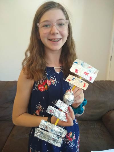 Young girl holding a project she created during Virtual Camp KSC