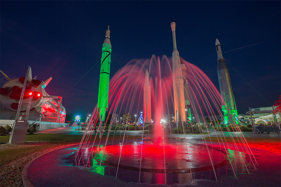 The Rocket Garden fountain displays festive colors for Holidays in Space at Kennedy Space Center Visitor Complex.