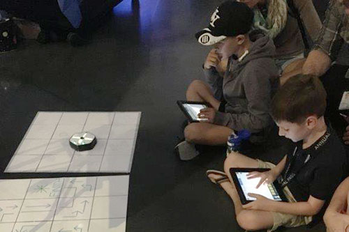Kids sending directional instructions to a robot.