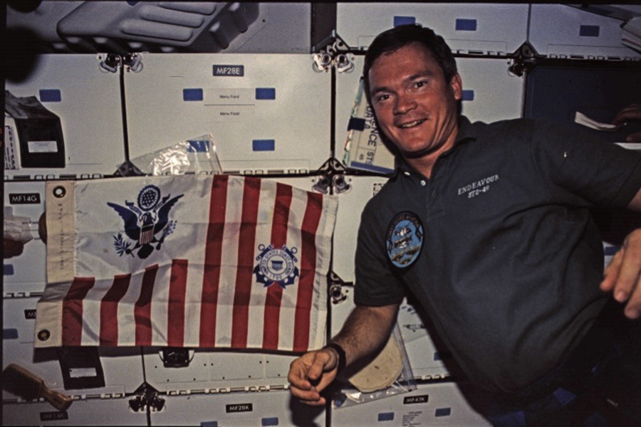 Bruce Melnick with U.S. Coast Guard flag on International Space Station