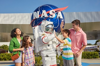 Astronaut high five in front of NASA meatball