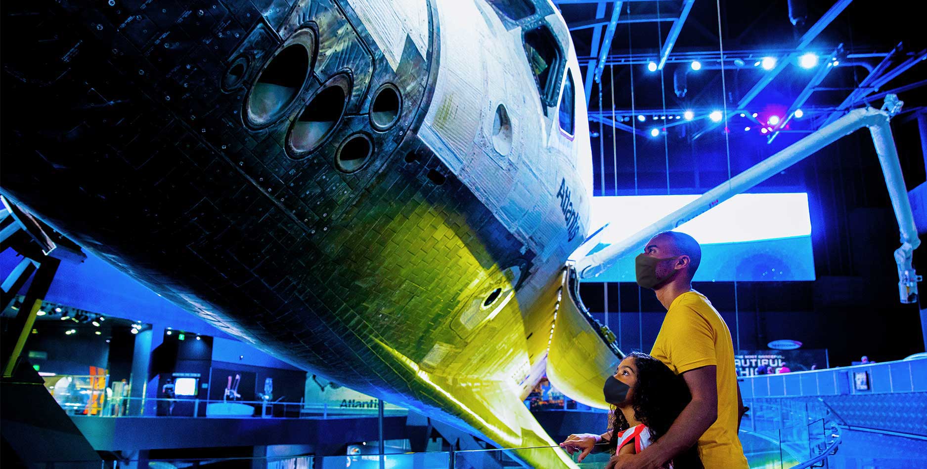 Father and daughter look up at space shuttle Atlantis