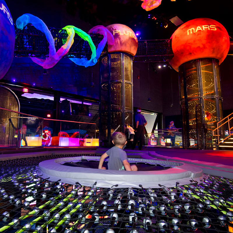 El sumidero gravitatorio de Planet Play, en el Complejo de Visitantes del Centro Espacial Kennedy, permite a los jóvenes exploradores trepar por un tubo de red vertical desde el primer piso hasta el segundo.