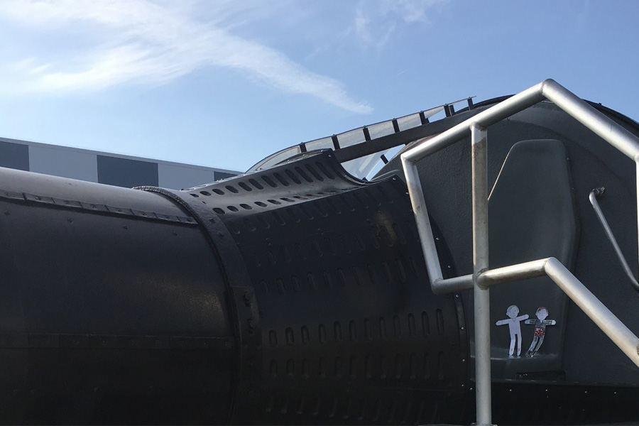 Flat Stanley e Flat Stanley sentam-se juntos na maquete da cápsula Gemini no Rocket Garden no Kennedy Space Center Visitor Complex.