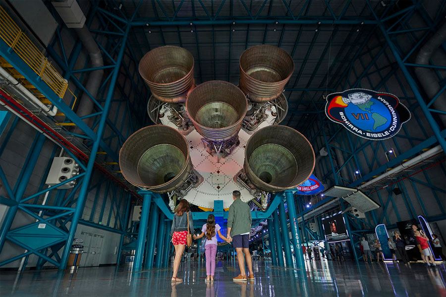 A família olha com admiração para o foguete Saturn V em exibição no Kennedy Space Center Visitor Complex.